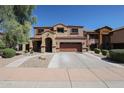 Two-story stucco home featuring a two-car garage, tile roof, arched entry, and landscaped front yard at 22927 N 41St St, Phoenix, AZ 85050