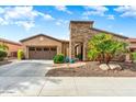 Charming single-story home featuring a stone accent wall, well-manicured landscaping, and a two-car garage at 29412 N 128Th Ln, Peoria, AZ 85383