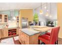 Bright kitchen featuring wooden cabinets, stainless steel appliances, and an island with seating at 3101 E Acoma Dr, Phoenix, AZ 85032