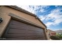 Close up view of a brown garage door on a sunny day at 40433 W Hensley Way, Maricopa, AZ 85138