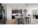 Modern kitchen with granite countertops, stainless steel appliances, and pendant lighting at 40433 W Hensley Way, Maricopa, AZ 85138