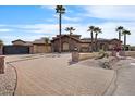 Daytime view of desert landscaping, mature palm trees, and a brick driveway leading to the luxurious home at 5203 N 179Th Dr, Litchfield Park, AZ 85340
