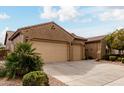 Beautiful single-story home with a xeriscaped yard, mature tree, and a three-car garage at 6473 W Victory Way, Florence, AZ 85132