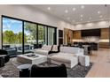 Open-concept living room with hardwood floors, a modern sofa, and a large sliding glass door at 7120 E Paradise Ranch Rd, Paradise Valley, AZ 85253