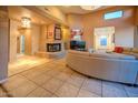 Open-concept living room with a fireplace, comfortable seating, tile flooring, and neutral tones throughout at 7169 E Bramble Berry Ln, Scottsdale, AZ 85266