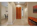 A view of the bright foyer featuring a wooden front door and tile floors at 7445 E Eagle Crest Dr # 1094, Mesa, AZ 85207