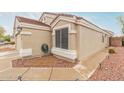 Close-up view of the side of the home showing neutral stucco and a well-manicured landscape at 11330 W Eden Mckenzie Dr, Surprise, AZ 85378