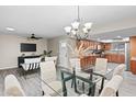 Open floor plan featuring a dining area with a glass table and modern chandelier at 11431 N 37Th Pl, Phoenix, AZ 85028