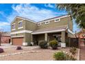 Charming two-story home boasts desert landscaping, rock accents and a covered porch at 12162 W Dreyfus Dr, El Mirage, AZ 85335