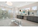 Luxurious primary bathroom featuring double vanity, rainfall shower, pendant lighting, and designer finishes at 13613 N 76Th St, Scottsdale, AZ 85260