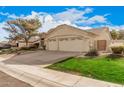 This home features a two-car garage, desert landscaping, and a well-manicured lawn at 16811 S 11Th Way, Phoenix, AZ 85048