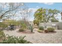 Serene backyard with a fountain, dining set, built-in grill, and mature desert plants at 18282 N 92Nd St, Scottsdale, AZ 85255