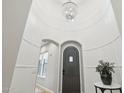 Elegant foyer with high ceilings, chandelier, dark wood front door, and arched doorways at 18282 N 92Nd St, Scottsdale, AZ 85255