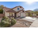 Lovely home with a tile roof, neutral stucco, rock landscaping, and a driveway leading to a two-car garage at 18421 N 12Th Way, Phoenix, AZ 85022