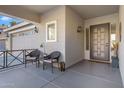 Covered front porch with decorative chairs and potted plants, showcasing a welcoming entrance at 19025 E Raven Dr, Queen Creek, AZ 85142