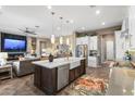 Gourmet kitchen island with farmhouse sink, pendant lighting, and a view into the living room with fireplace at 20551 E Mayberry Rd, Queen Creek, AZ 85142