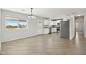 Bright living room featuring natural light, wood-look floors, and an open layout to the kitchen at 21189 E Blue Jay Ln, Florence, AZ 85132