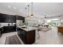 Open-concept kitchen featuring dark cabinets, a granite countertop island, and open flow to the living area at 21413 N 59Th St, Phoenix, AZ 85054