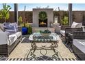 Inviting outdoor living space with a fireplace, comfortable seating, and desert landscape views at 21413 N 59Th St, Phoenix, AZ 85054