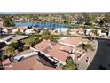 Aerial view of a residential neighborhood with homes, landscaping, and a serene lake at 26637 S New Town Dr, Sun Lakes, AZ 85248