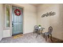 Inviting front porch with a decorative wreath on the door and a cozy seating area at 29588 N 129Th Dr, Peoria, AZ 85383