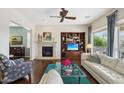 Cozy living room featuring a fireplace, built-in shelves, hardwood floors, and a comfortable sofa at 29588 N 129Th Dr, Peoria, AZ 85383