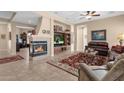 Inviting living room with a cozy fireplace, tile flooring, and a comfortable seating area at 4221 E Sourwood Dr, Gilbert, AZ 85298