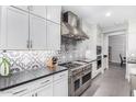 Modern kitchen featuring white cabinets, stainless steel appliances, and patterned tile backsplash at 4455 S Matter --, Mesa, AZ 85212