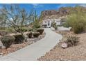 Beautiful stucco home with a winding driveway and desert landscaping, nestled in a mountainous landscape at 4822 S Gold Canyon Dr, Gold Canyon, AZ 85118