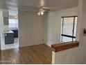 Bright living room features hardwood floors, ceiling fan, and a view into the kitchen area at 5323 W Seldon Ln, Glendale, AZ 85302