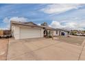 This home features solar panels, a 2-car garage, a rock yard, and a blue front door at 627 W Flower Ave, Mesa, AZ 85210