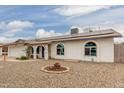 Attractive home features solar panels, gravel yard, arched windows, and a blue front door at 627 W Flower Ave, Mesa, AZ 85210