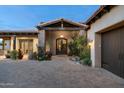 The entrance has a covered entry with stone accents and a charming front door at 7363 E Lower Wash Pass, Scottsdale, AZ 85266