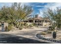 Charming home showcasing desert landscaping, mature trees, and an inviting entrance at 7363 E Lower Wash Pass, Scottsdale, AZ 85266