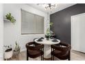 Chic dining area with a modern table, stylish lighting, and serene window views at 7840 W Bonitos Dr, Phoenix, AZ 85035