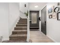 Inviting entryway with a modern gray door and a staircase leading to the upper level at 7840 W Bonitos Dr, Phoenix, AZ 85035