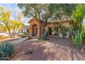 Inviting front exterior with a brick archway, desert landscaping, and a mature shade tree at 8005 N Via De Lago --, Scottsdale, AZ 85258