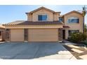 Two story home featuring a tile roof, three car garage, and neutral desert landscaping at 835 E Stirrup Ln, San Tan Valley, AZ 85143