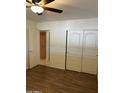 Bedroom with a view into the ensuite, wood-look floors, and a ceiling fan at 8538 E Vista Dr, Scottsdale, AZ 85250