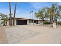 Attractive home exterior with manicured lawn, large driveway and palm trees at 8709 E Mackenzie Dr, Scottsdale, AZ 85251