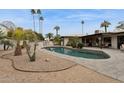 Backyard swimming pool with desert landscaping and covered patio dining area at 8709 E Mackenzie Dr, Scottsdale, AZ 85251