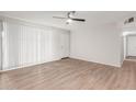 Bright living room with fan, wood floors, and door to hallway at 9033 N 15Th Dr, Phoenix, AZ 85021