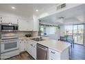 Bright kitchen featuring white cabinets, stainless steel appliances, and a cozy dining area with natural light at 9275 E Mission Ln # 206, Scottsdale, AZ 85258