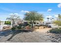 Desert home showcasing lush landscaping, mature trees, and a paved driveway at 9331 E La Posada Ct, Scottsdale, AZ 85255