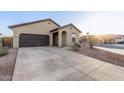 Charming home featuring a two-car garage, desert landscaping, and a welcoming entryway at 9539 W Agora Ln, Tolleson, AZ 85353