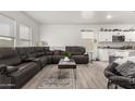 Spacious living room features wood floors, bright white walls, and stylish furniture at 9539 W Agora Ln, Tolleson, AZ 85353