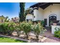 Charming home exterior with lush rose bushes, manicured lawn, and stucco facade at 9921 E Doubletree Ranch Rd, Scottsdale, AZ 85258