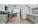 Modern kitchen featuring stainless steel appliances, stylish gray cabinets, quartz countertops, and wood flooring at 10252 N 46Th Dr, Glendale, AZ 85302