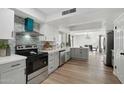 Bright, updated kitchen boasts stainless steel appliances, gray cabinets, and a view into the dining area at 10252 N 46Th Dr, Glendale, AZ 85302