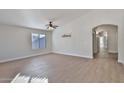 Bright, open living room with wood-look tile flooring and arched entryway at 10353 W Atlantis Way, Tolleson, AZ 85353